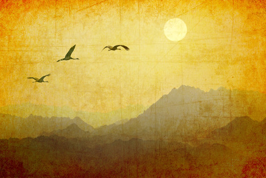 Migrating birds flying to the sun over the mountains. Flock of cranes in the sky against beautiful nature landscape. Old paper texture. Retro style image