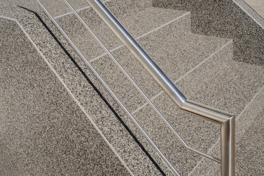 Moderner Handlauf und Edelstahlgel&auml;nder an einer Betontreppe mit Kieselbeschichtung - Contemporary handrail and stainless steel railing on a concrete staircase with gravel coating