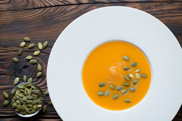 Above view of white glass plate with pumpkin cream-soup