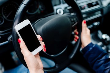 Woman holding a white smartphone with blank screen