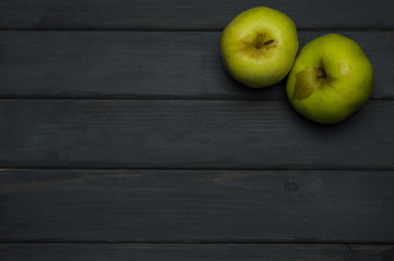 Whole and cut red and green ripe apples autumn harvest and apple juice, from above on dark grey wooden table