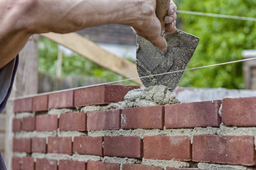 Trowel spreading cement on bricks