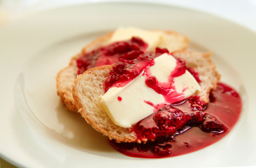 tasty fresh white bread with butter and raspberry jam