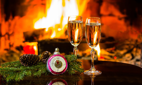 Two glasses of wine and Christmas New Year decoration, fireplace