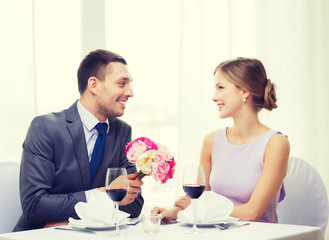 smiling man giving flower bouquet at restaurant
