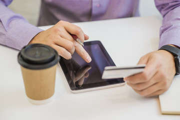 Businessman using a credit card and digital tablet for buying on line