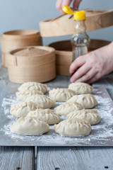 The process of making Asian dumplings. Female hands in the background 