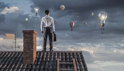 Young businessman on roof . Mixed media © Sergey Nivens