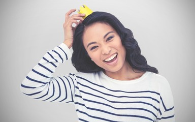Composite image of smiling asian woman with paper crown