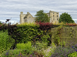 Traditional garden planting with the ruins of Helmsley Castle, Helmsley, North Yorkshire, England in the background - 123649283