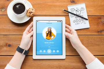 close up of woman with tablet pc on wooden table