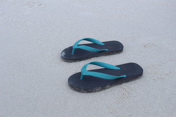 Flip flops on a sand beach