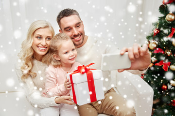 Fototapeta na wymiar family taking selfie with smartphone at christmas