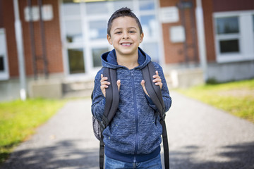 student outside school standing smiling