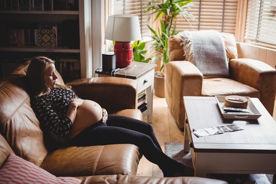 Pregnant woman relaxing in living room