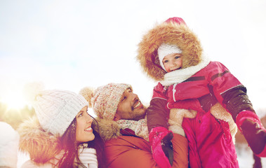 happy family with child in winter clothes outdoors