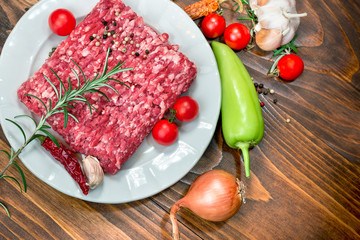 Fresh raw minced beef - ground beef on white plate and vegetables