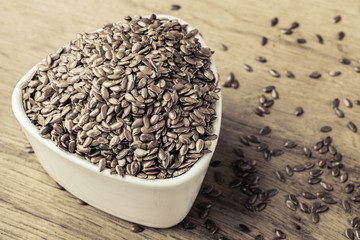 Flax seeds linseed in bowl on wooden table