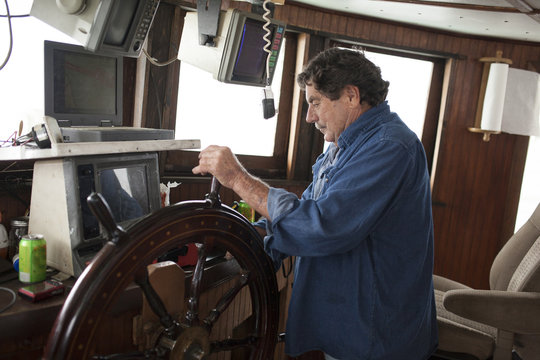 Commercial fishing boat captain at the wheel
