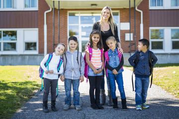 students outside school teacher standing together