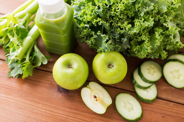 close up of bottle with green juice and vegetables