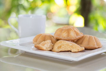 Egg cake, delicious dessert and black coffee in white dish on ti