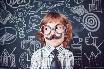 Little boy as businessman or teacher with mustache and glasses standing on dark background pattern. Wearing shirt, tie. close-up
