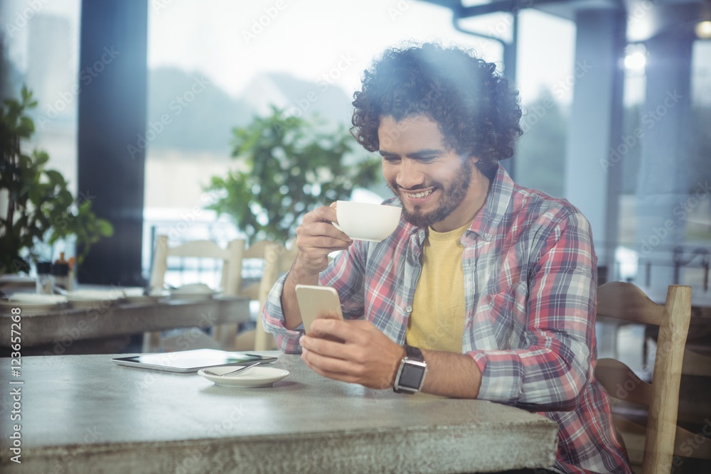Poster Man using mobile phone while having coffee