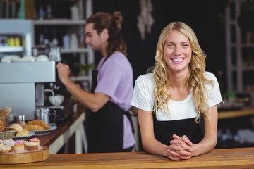 Obraz premium Portrait of smiling waitress standing at counter