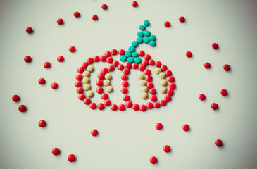 Symbol Halloween Holiday - a  yellow orange pumpkin made of small round candies. Isolated on a white background.