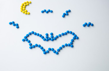 Halloween Holiday scary fly bat or flittermouse and moon made of round small chocolate color candy. Isolate on white background.