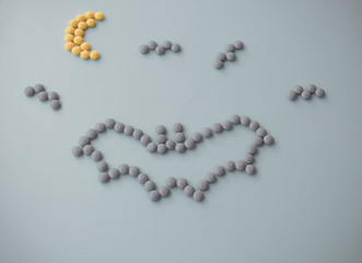 Halloween Holiday scary fly bat or flittermouse and moon made of round small chocolate color candy. Isolate on white background.