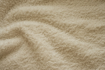 Бежевое махровое полотенце складки текстура. Натуральная хлопковая махровая ткань