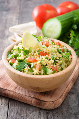 Tabbouleh salad with couscous on rustic wooden table

