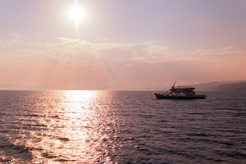 Naklejka na ściany i meble Boat sailing in sea against sky during sunset