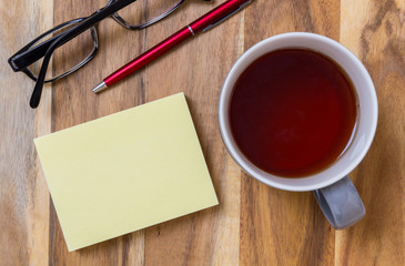 Notizblock mit Tee Hintergrund auf Holz Konzept