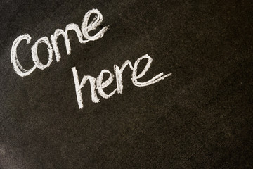 Надпись иди сюда белый мел чёрная доска