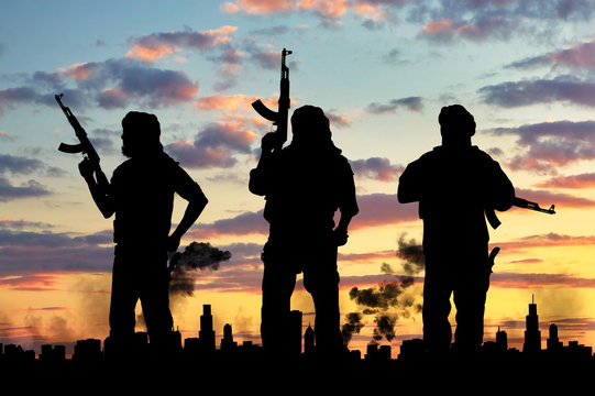 Silhouette of men holding rifle against cloudy sky