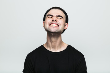 Studio portrait of adult man feeling pain with his eyes closed on white background.