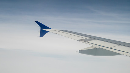 Fototapeta na wymiar The airplane wing on the beautiful cloudy and sky.