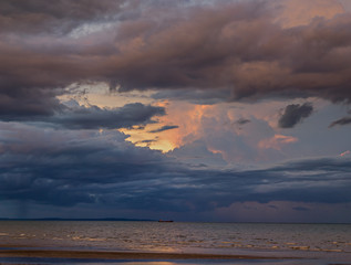 Naklejka na ściany i meble a cloudy sunset in a beach scene