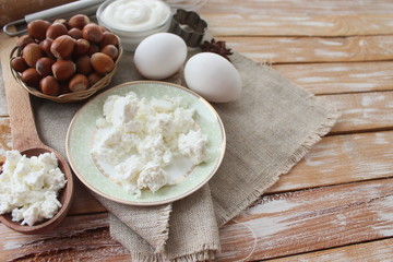 Fototapeta na wymiar Ingredients for baking - milk eggs cheese nuts flour wheat, wood background