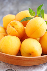 apricots in a wooden plate with mint leaves