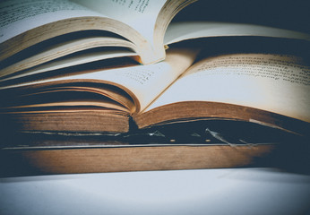 Pile of old books.
old book open with another books 