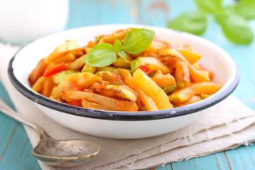 ragout of zucchini and tomato with garlic and basil, in a white plate, selective focus