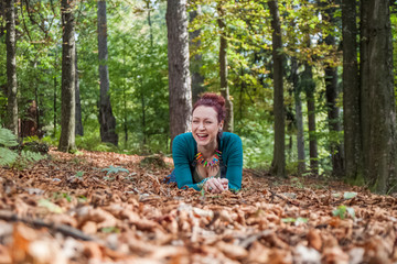 Girl on the leaves laying and smiling