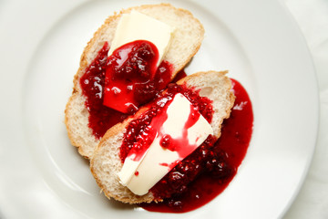 tasty fresh white bread with butter and raspberry jam