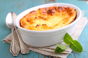 Cottage cheese casserole in white dish, on a blue background