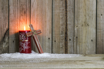 Red holiday candle with wooden cross