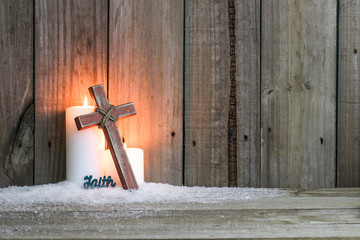 White candles, wood cross and the word Faith